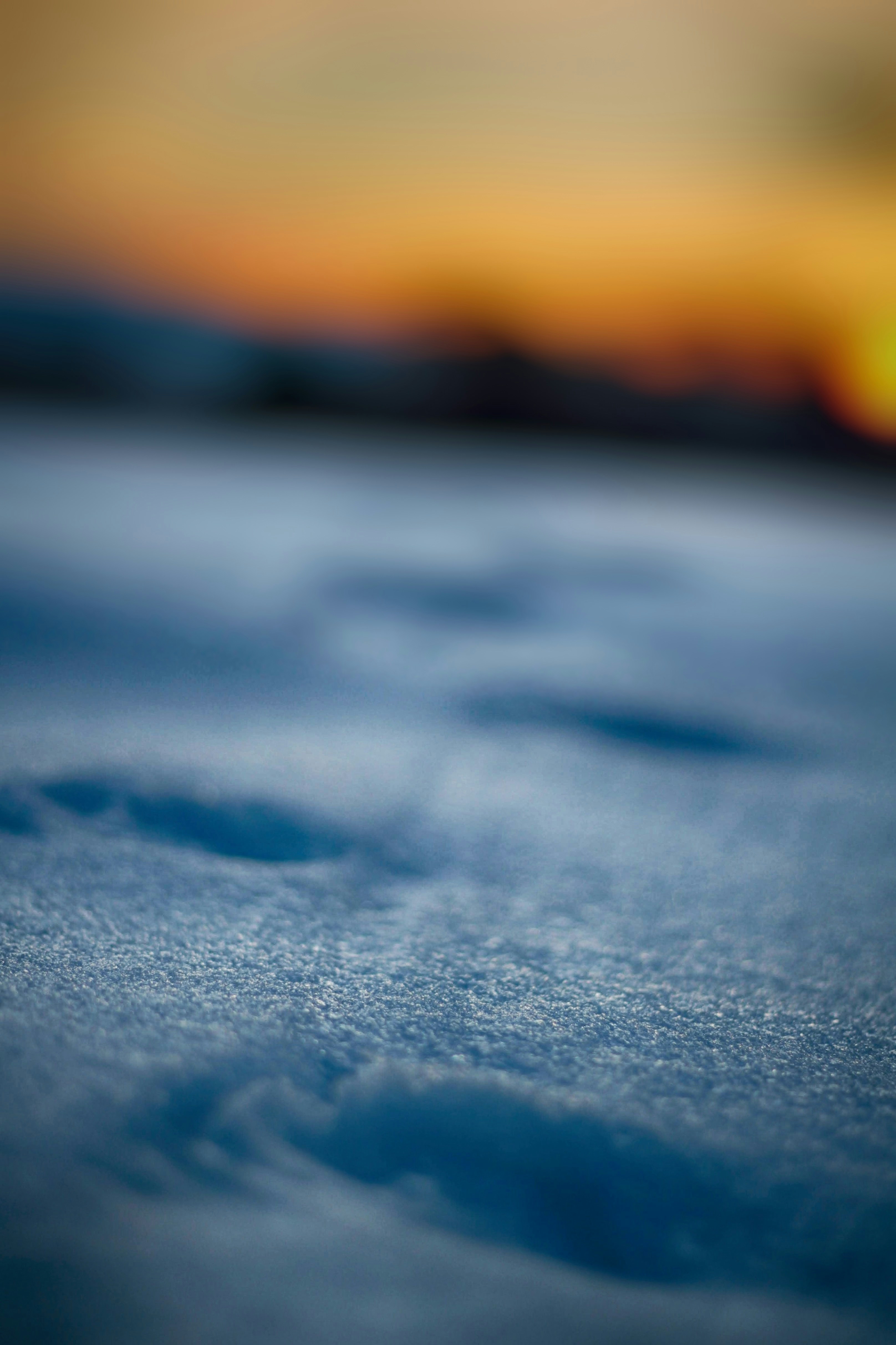 neve bianca su sabbia grigia durante il tramonto