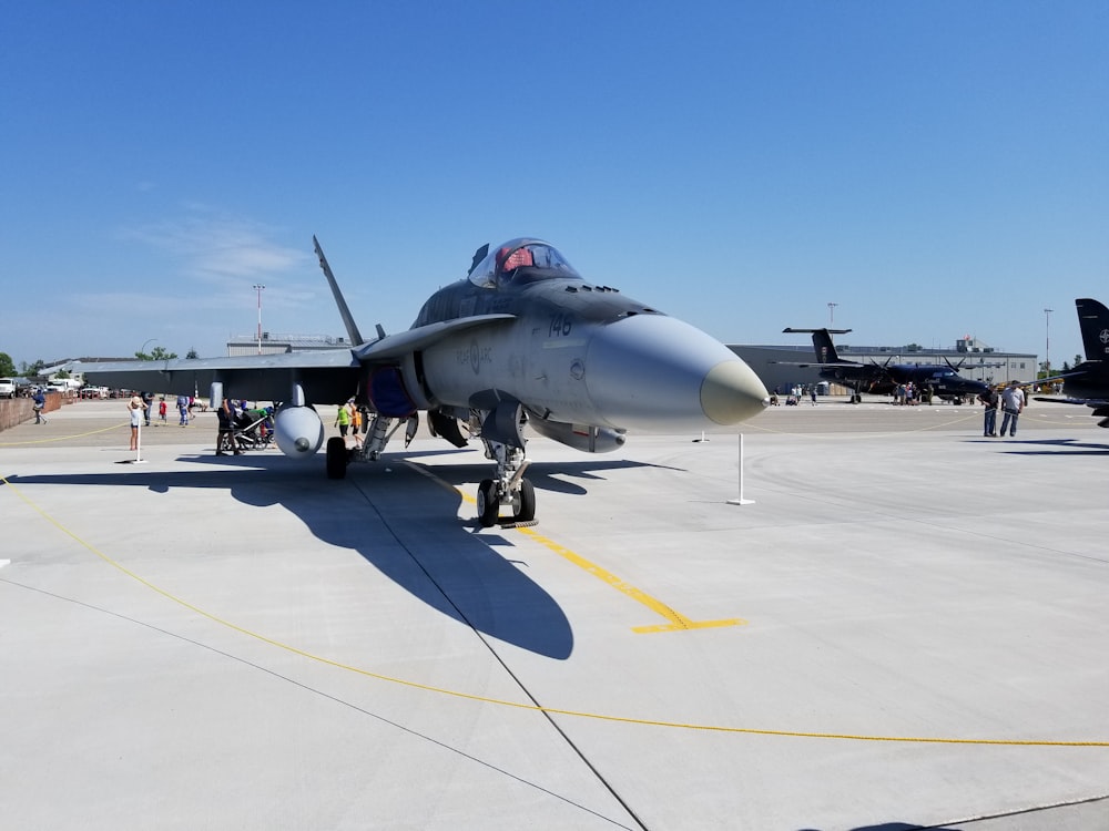gray fighter jet on gray concrete pavement during daytime