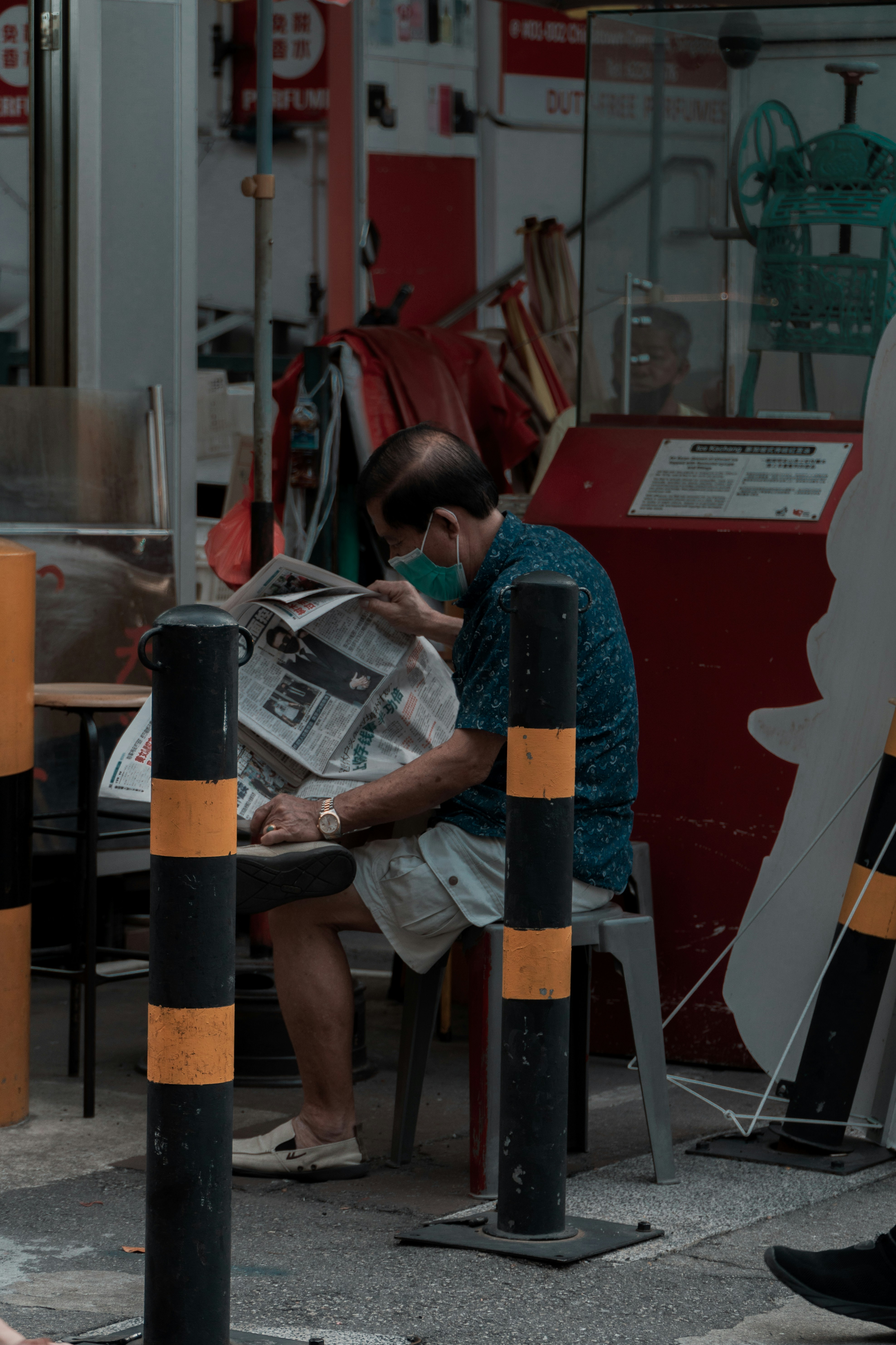 man in gray t-shirt sitting on black and orange metal stand