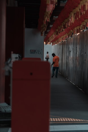 man in white t-shirt walking on hallway
