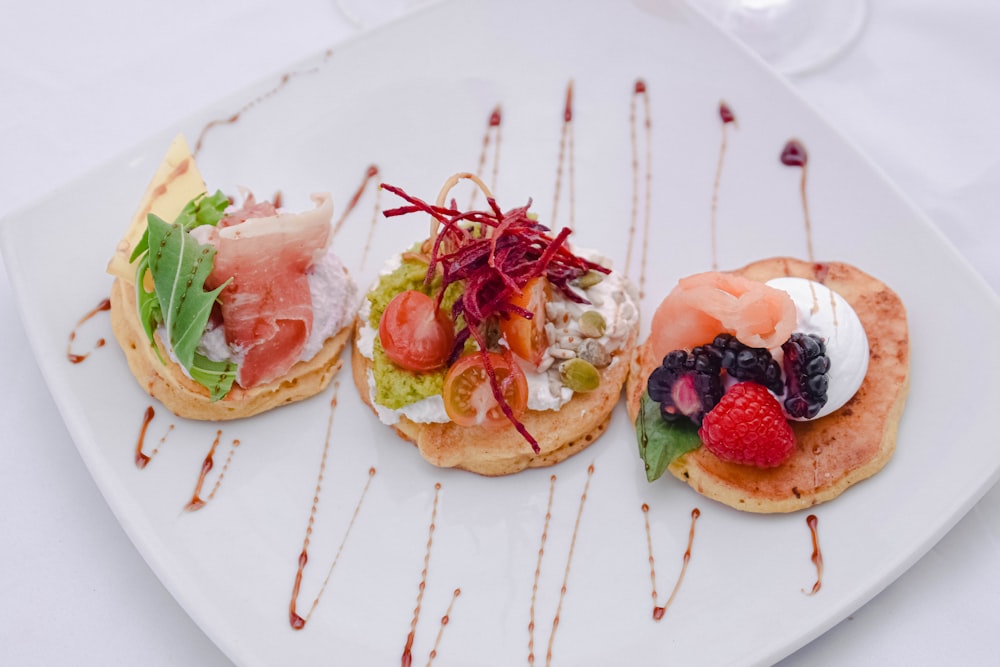 bread with sliced strawberry and green leaf vegetable on white ceramic plate