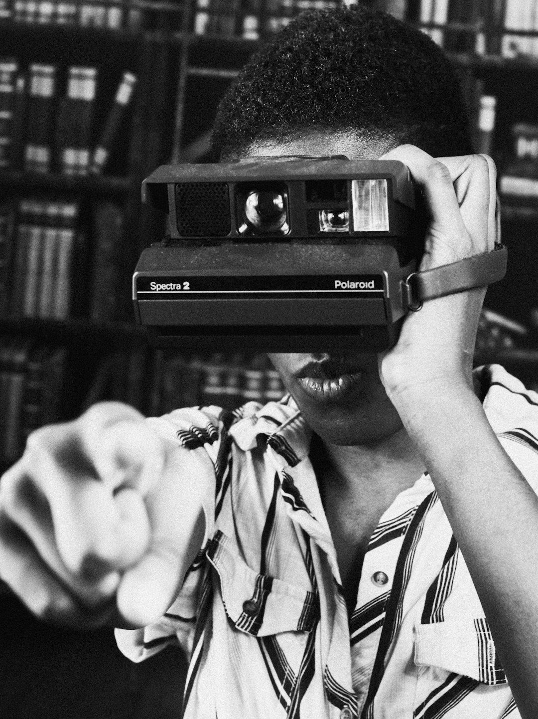 grayscale photo of woman holding polaroid camera