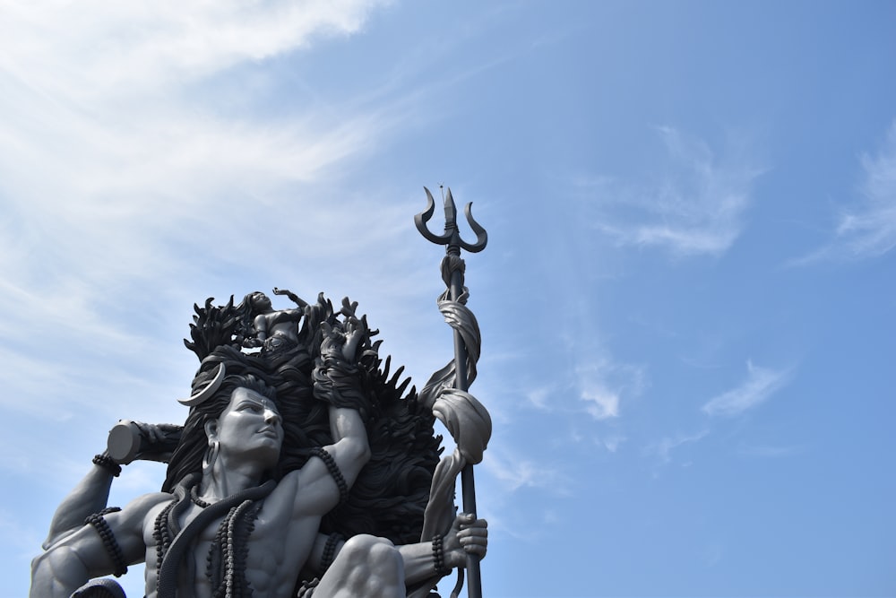 Estatua de hormigón negro bajo el cielo azul durante el día
