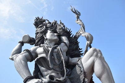 woman in black and white dress holding gold sword statue
