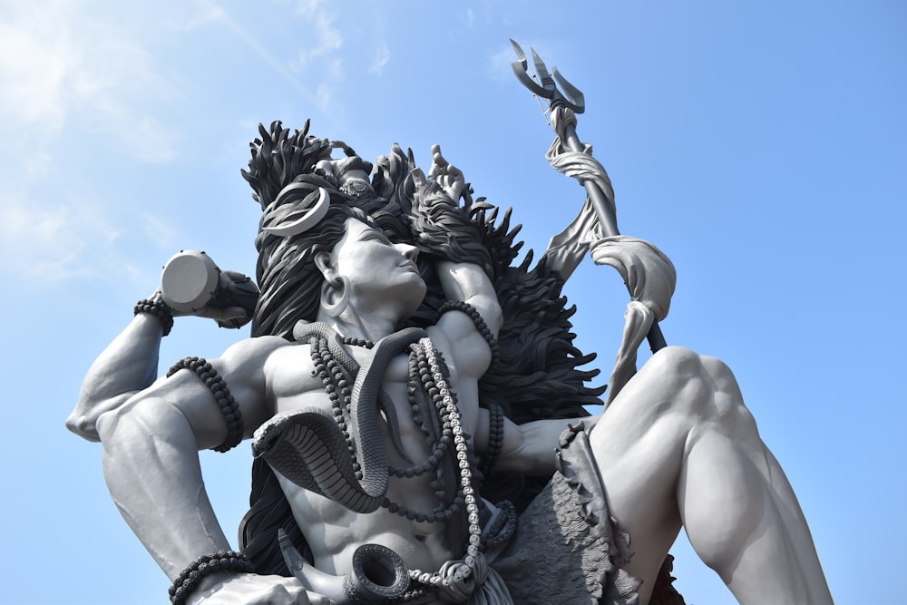 woman in black and white dress holding gold sword statue