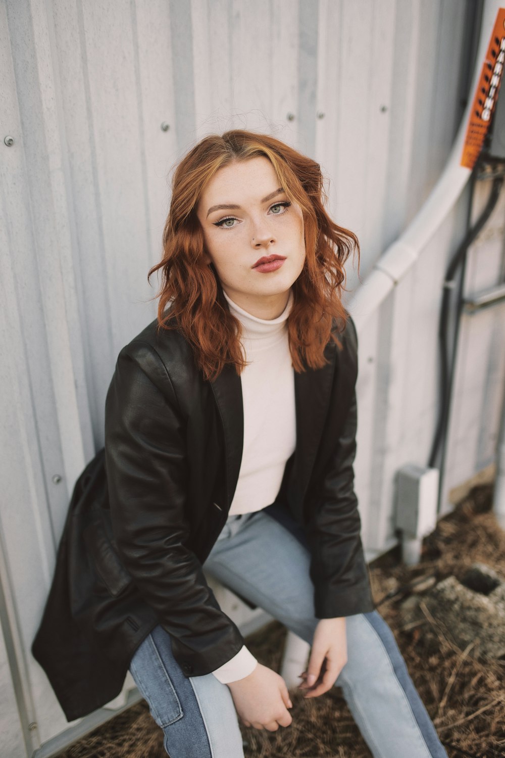 woman in black blazer and white shirt sitting on rock