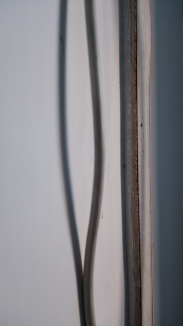 Close-up of a renter-friendly TV install using a cord concealer on a beige wall with minimal wall impact