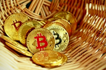 A collection of golden coins featuring the Bitcoin symbol rests inside a woven basket, creating a sense of abundance and wealth.