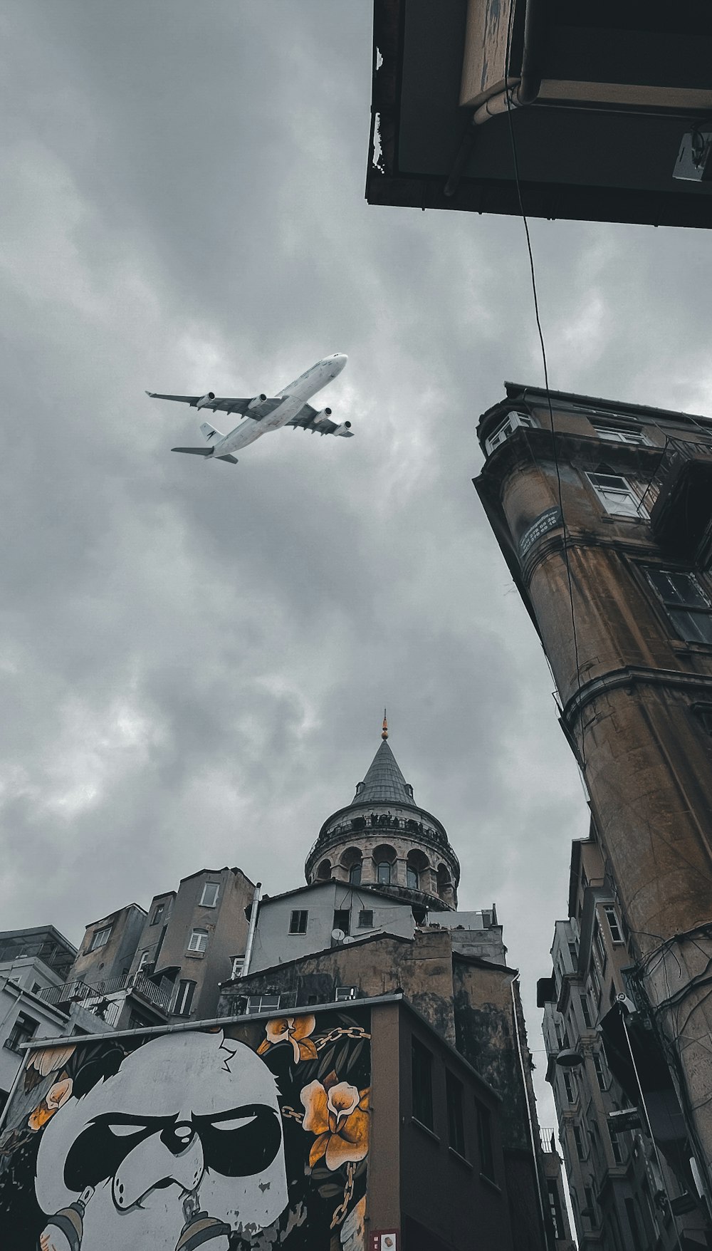 white airplane flying over brown concrete building during daytime