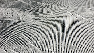 Steel track cleats gripping fresh snow under a grooming machine.