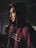 Close-up of a man with a calm expression wearing a Harmony Haven Warriors hoodie against a city backdrop.