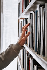 person in white long sleeve shirt holding white book