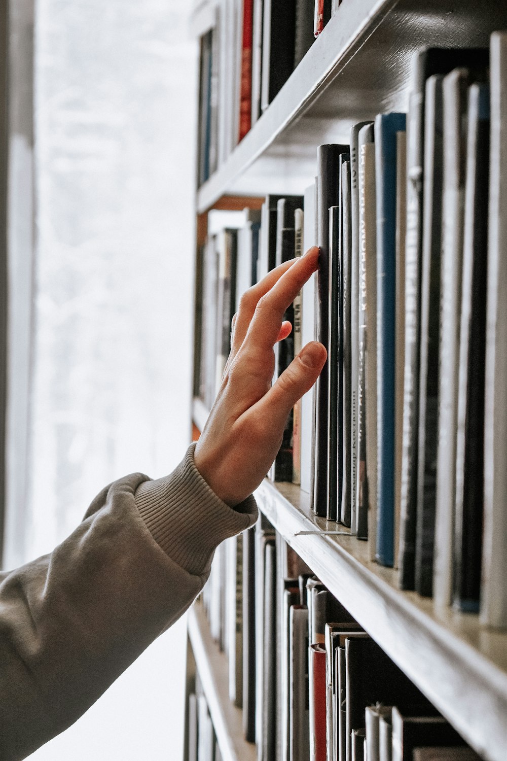 Personne en chemise blanche à manches longues tenant un livre blanc