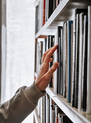 person in white long sleeve shirt holding white book