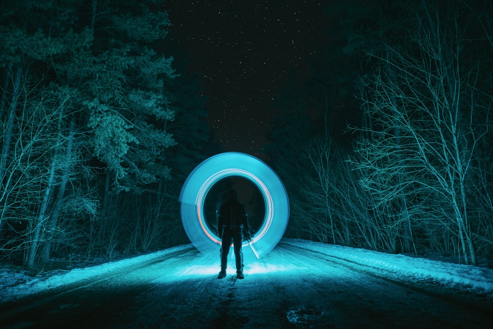 person in black jacket standing on snow covered ground during night time