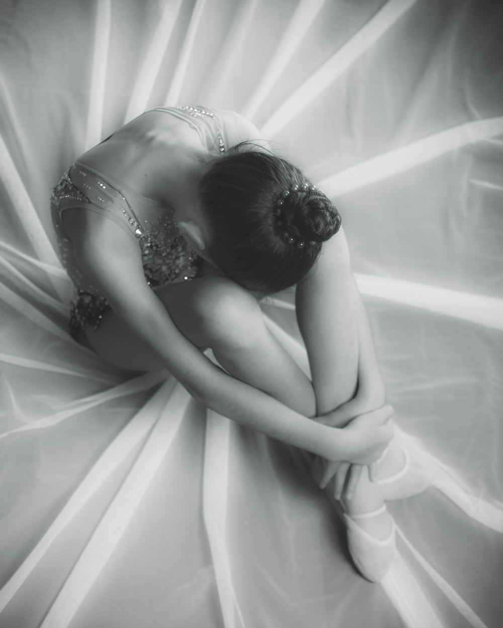 Femme en robe blanche allongée sur un textile blanc