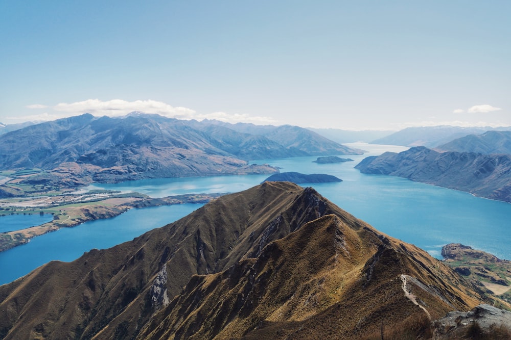 brown and green mountains near body of water during daytime