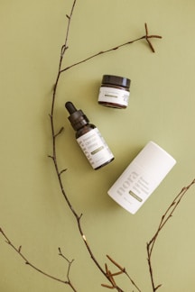 A serene arrangement of pastel green and earth-toned hair care bottles on a smooth wooden surface.