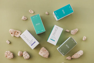 Minimalist arrangement of Safira's product line on a smooth stone surface with shadows.