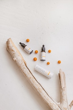 Close-up of natural skincare products with botanical elements on wooden surface.