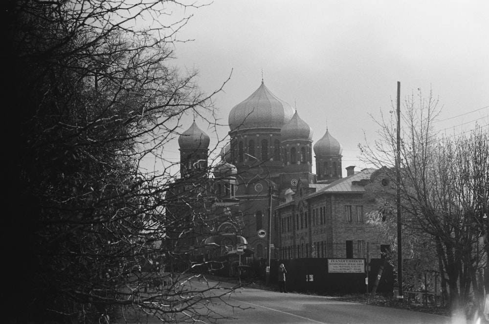 grayscale photo of building near bare trees