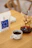 Photo of a Kalita Wave dripper on a wooden table with fresh coffee beans nearby.