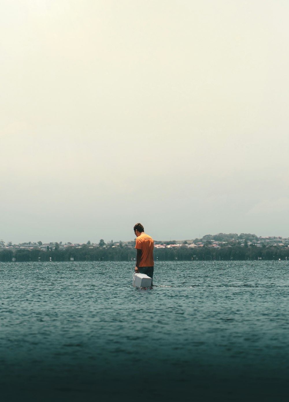 Hombre con camisa blanca de pie en la orilla del mar durante el día