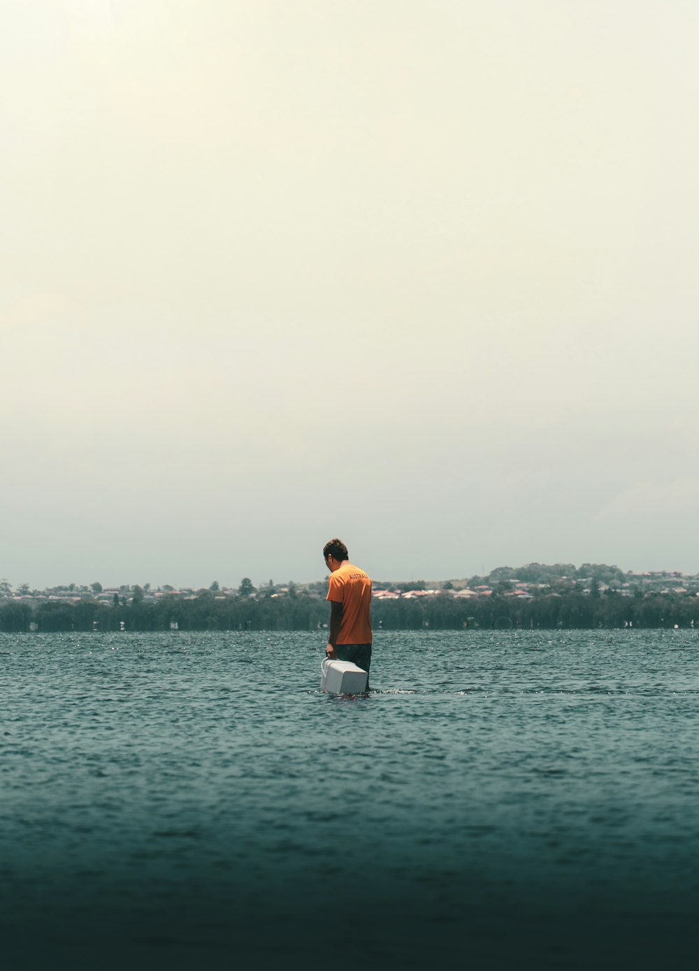 man in white shirt standing on sea shore during daytime