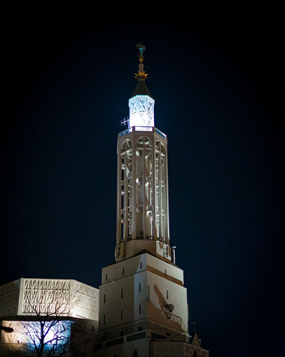 Weißes Betongebäude mit goldenem Kreuz oben