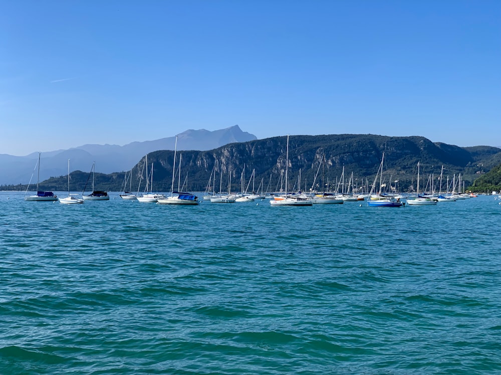 white boats on sea near mountain during daytime