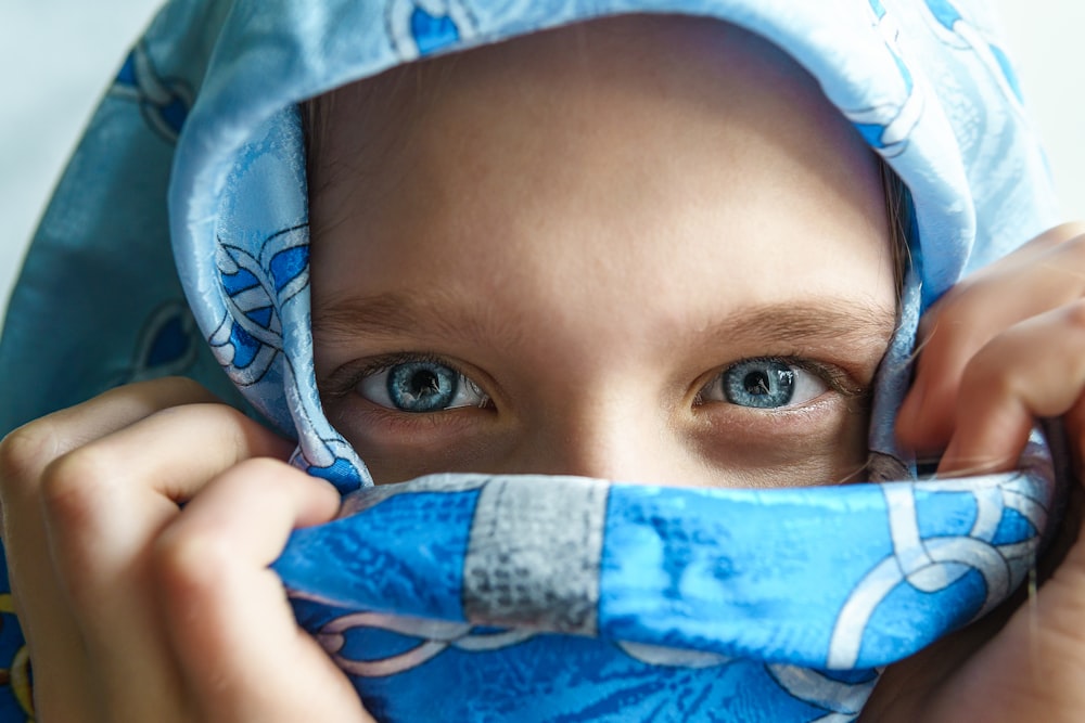 a close up of a person covering their face