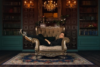 man in black jacket sitting on gray sofa chair