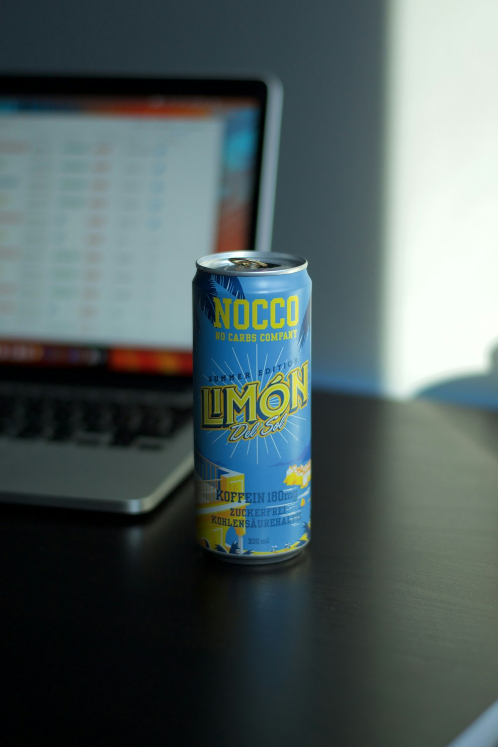 blue and yellow can on black laptop computer