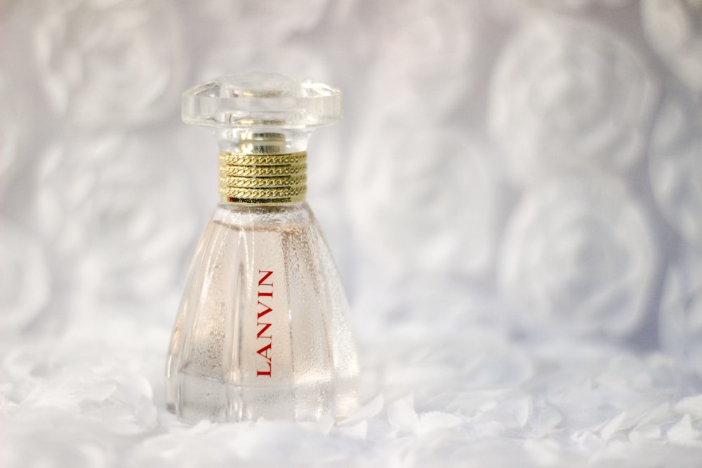 clear glass bottle on white textile