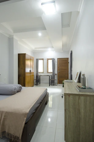 A quiet bedroom with simple, neat furnishings offering a restful personal space.