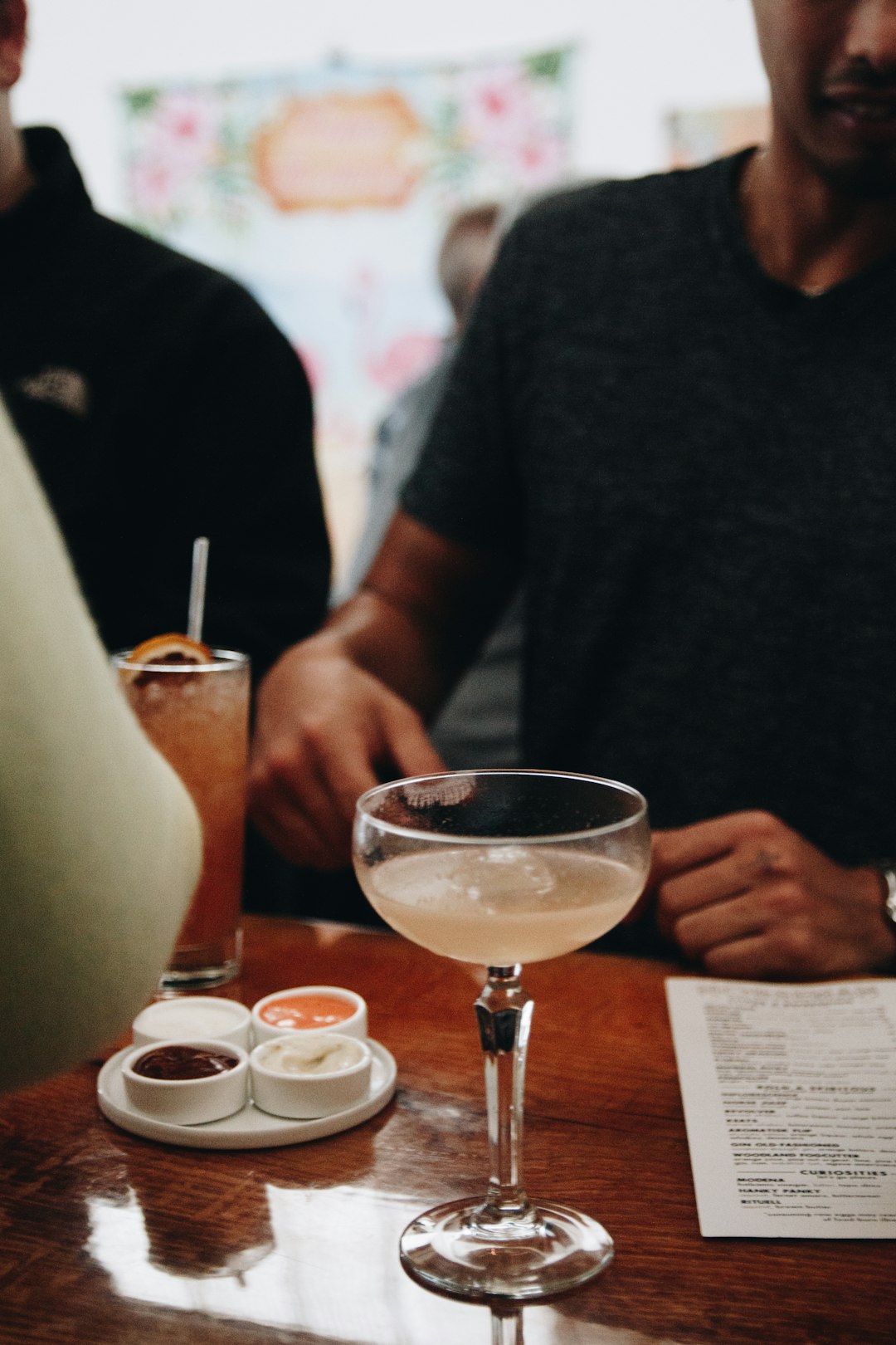 man in black crew neck shirt holding clear wine glass