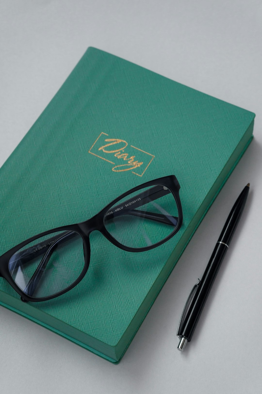 black frame eyeglasses on green book