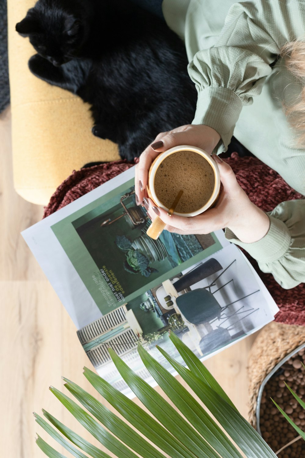 Persona sosteniendo una taza de cerámica blanca con líquido marrón