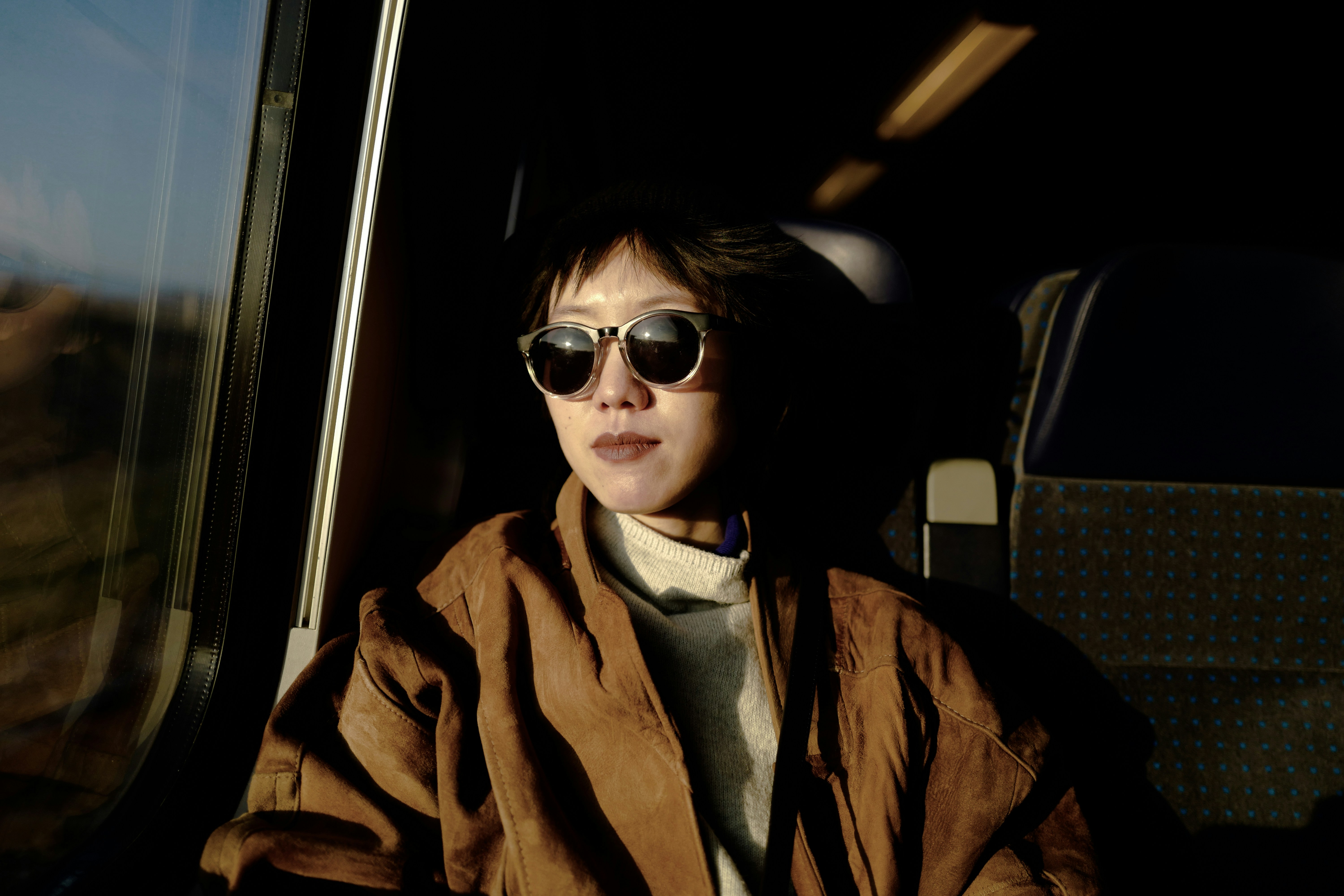 woman in brown coat wearing sunglasses, 