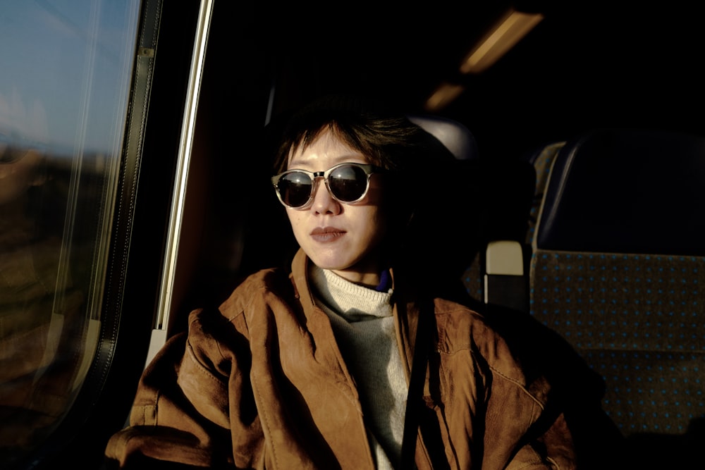 woman in brown coat wearing sunglasses