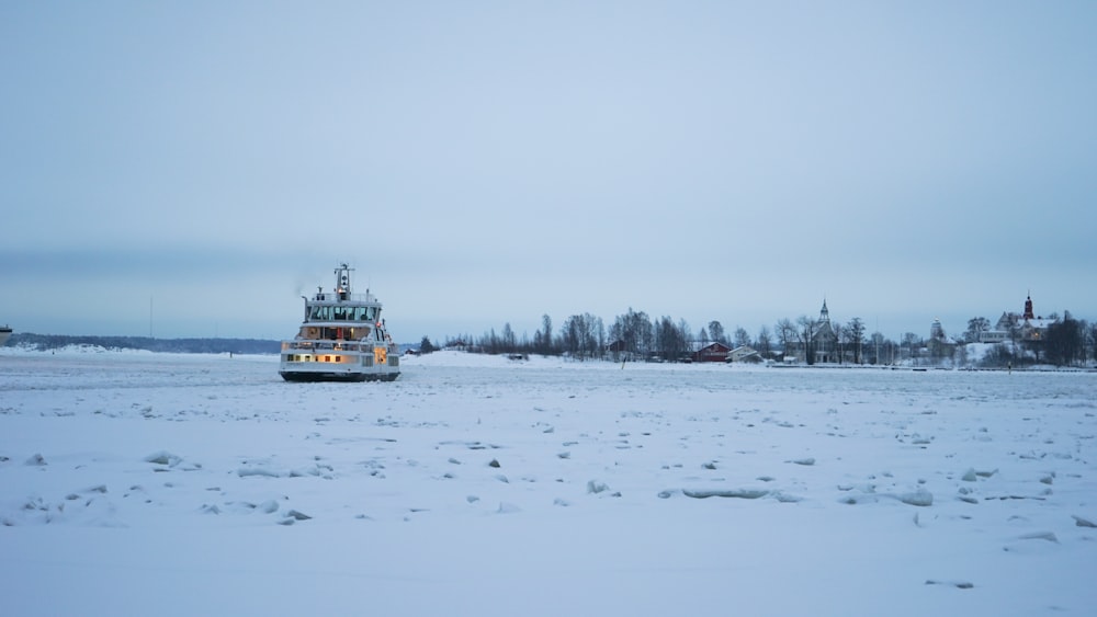 Barco blanco y azul en suelo cubierto de nieve durante el día