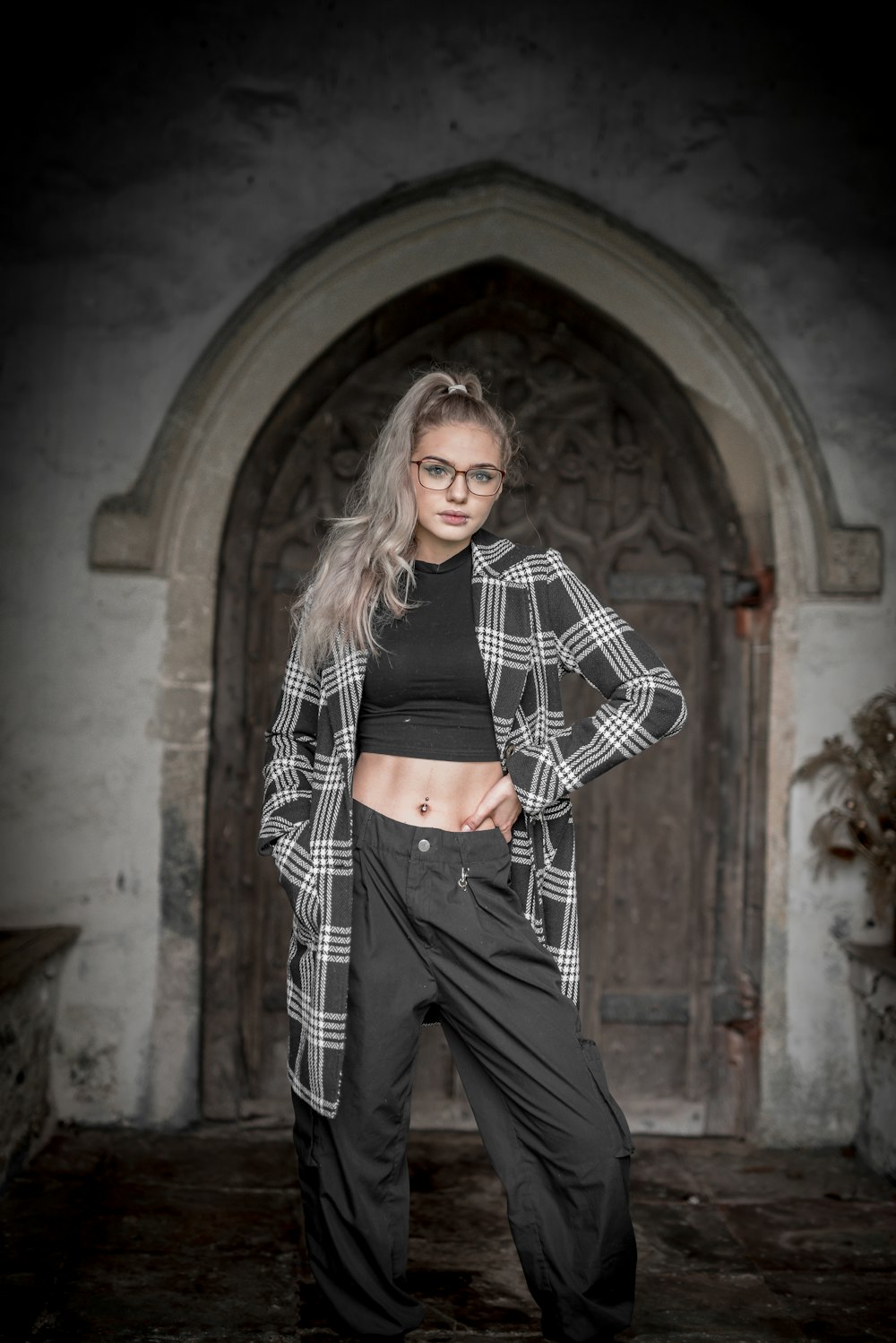 woman in black and white checkered long sleeve shirt and black pants standing on brown concrete