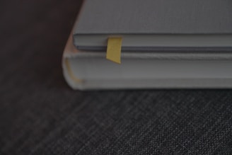 A close-up of hands holding freshly printed books with yellow and black covers.