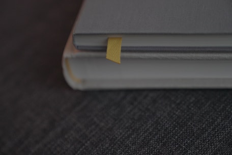 A close-up of hands holding freshly printed books with yellow and black covers.