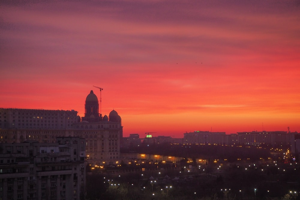 Una vista del tramonto di una città con un cielo rosso