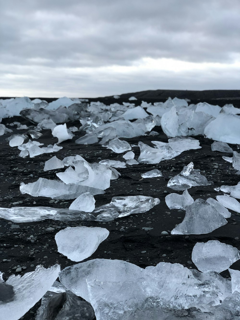 Glace sur le rivage rocheux noir pendant la journée