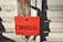 A red card with the word 'COMPASSION...' written in large black letters is attached to a metal latch on a weathered, rusted door.