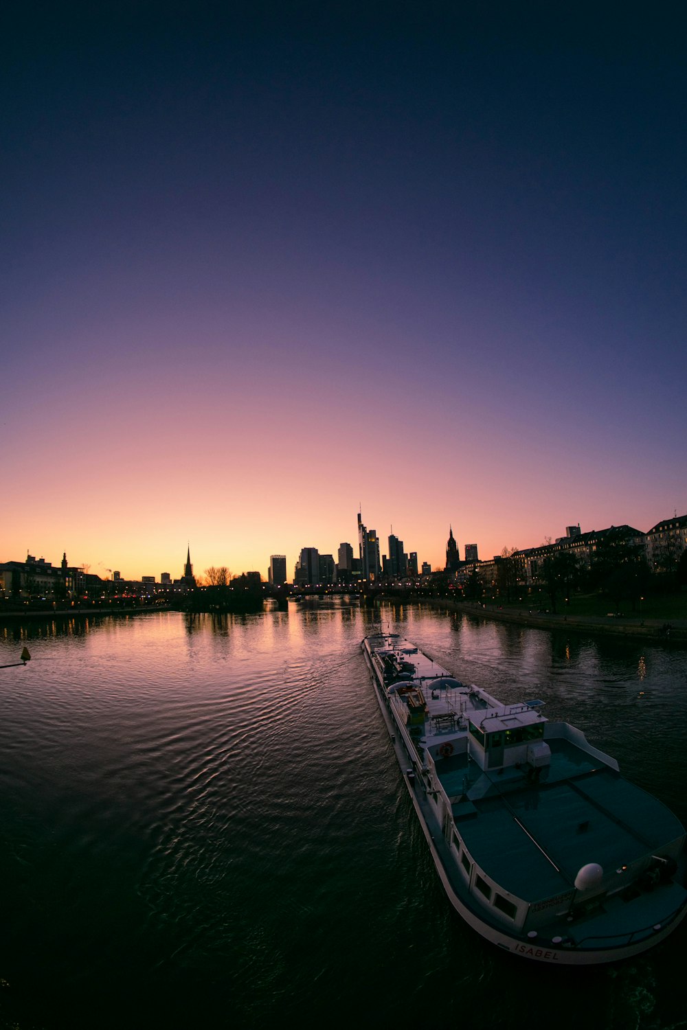 body of water near city buildings during sunset