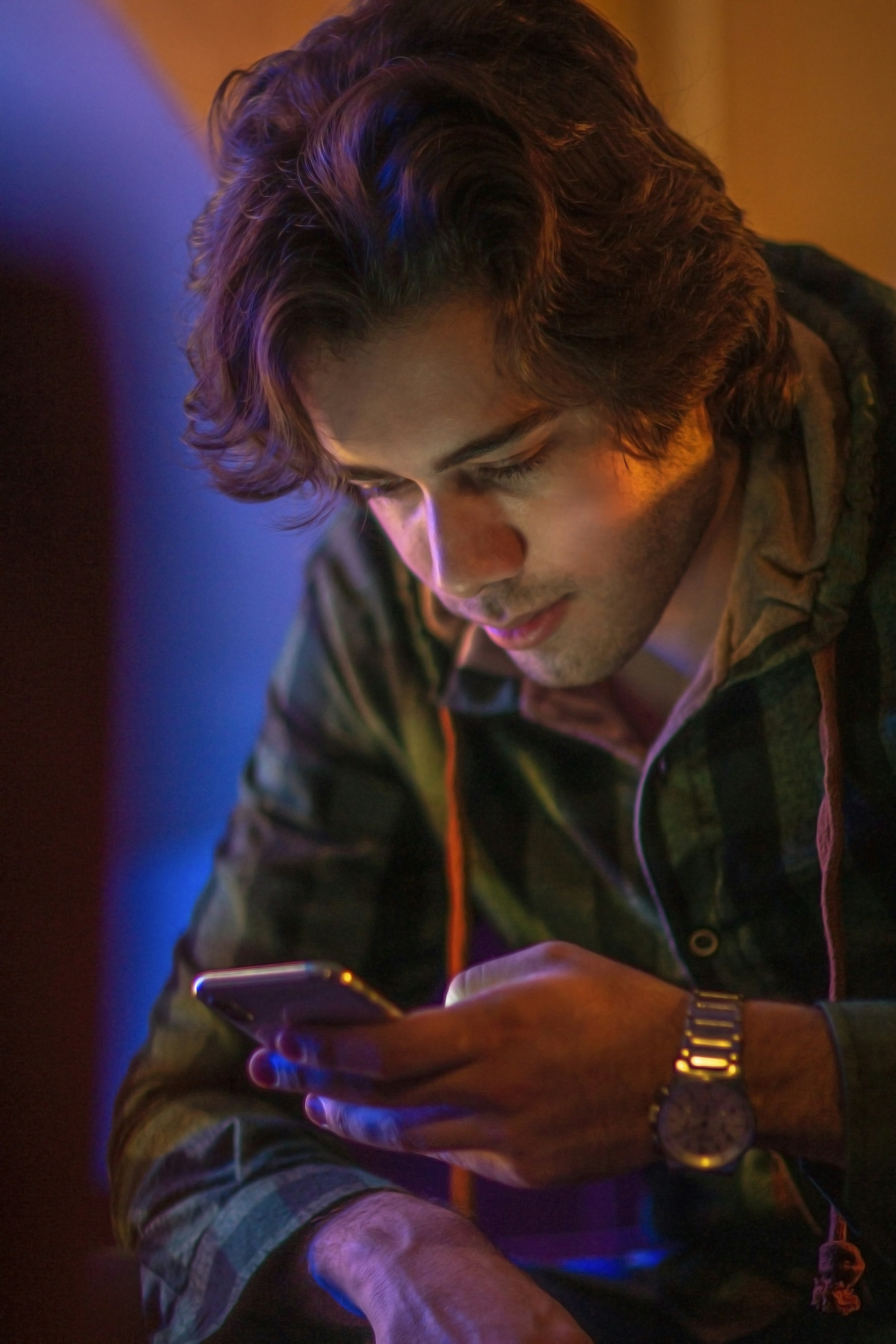 man in brown and black plaid button up shirt using smartphone