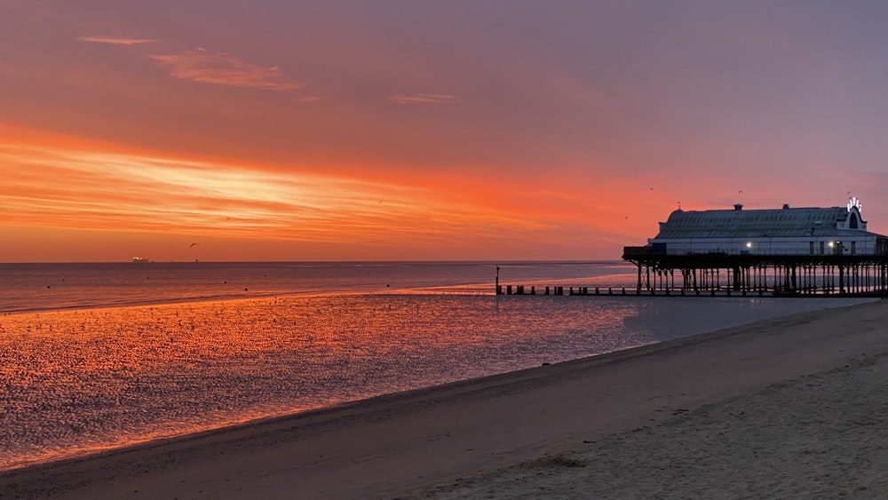 silhouette of dock on sea during sunset